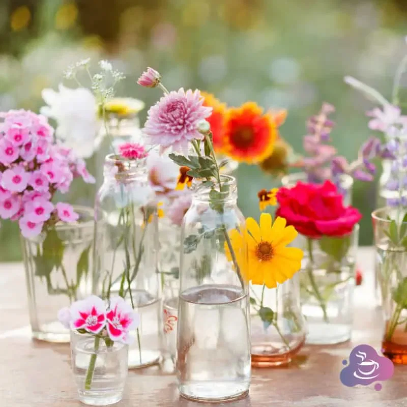 Blumenarrangement in Gläsern: Natürliche Farbenpracht und charmantes Gartenflair.