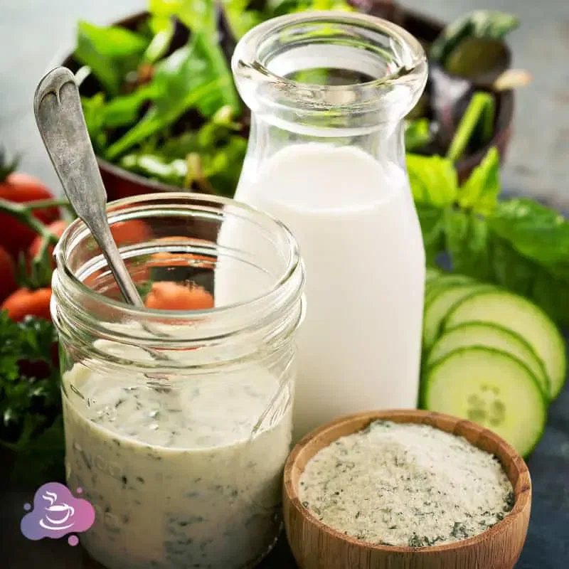 Frische Zutaten für gesunde Salate: Dressing, Milch, Salz, Gemüse und Kräuter.