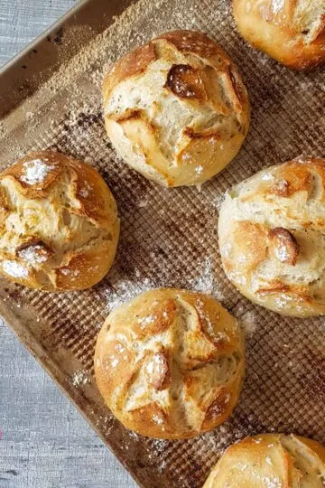 Frische, goldbraune Brötchen auf Blech – rustikal, knusprig, perfekt für den Genuss.