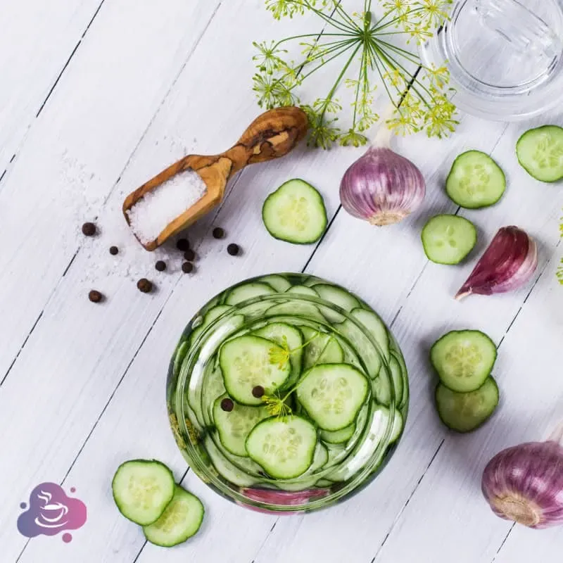 Frischer Gurkensalat mit Zwiebeln, Dill und Meersalz auf rustikaler Holzoberfläche.