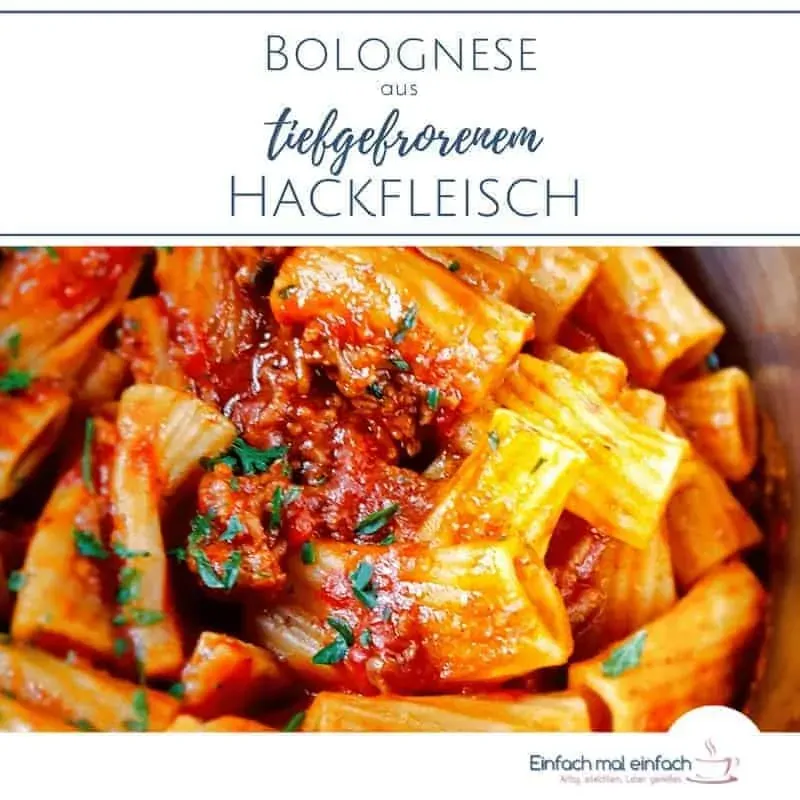 Nahaufnahme von Nudeln mit Hackfleischsoße und Petersilienstückchen im Topf.