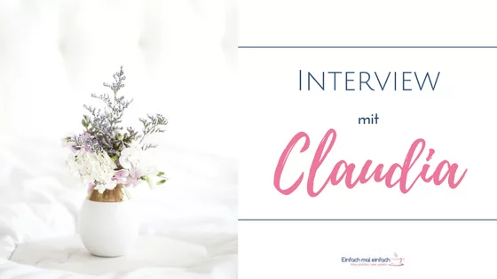 Weiße Vase mit lila und weißen Blumen auf Marmortablett vor hellem Hintergrund. Text:"Interview mit Claudia"