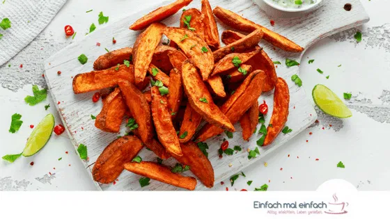 Kartoffelecken aus Süßkartoffeln auf hellem Untergrund. Text: