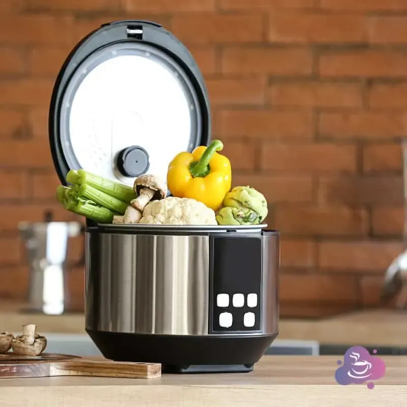 Moderner elektrischer Reiskocher mit frischem Gemüse in stilvoller Küchendekoration.