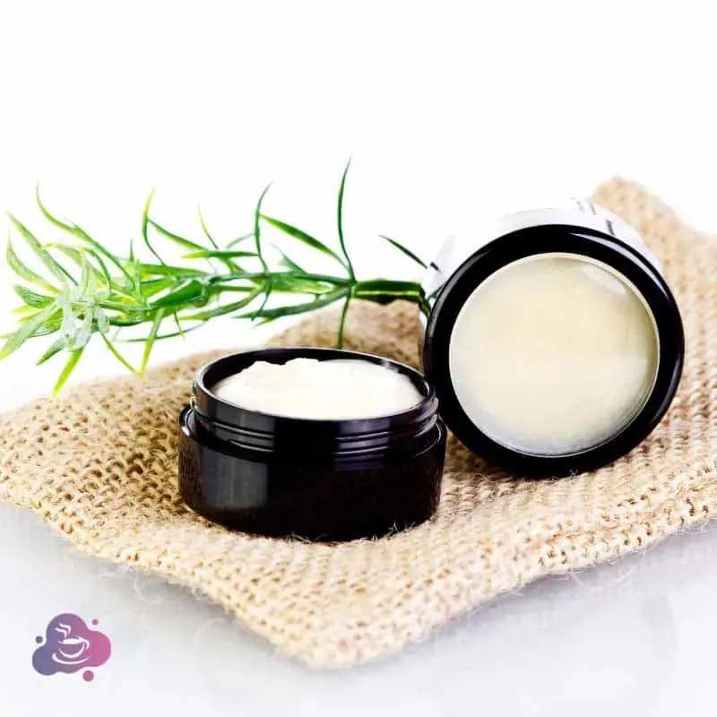 Natürliche Hautpflege in schwarzen Gläsern, mit grünen Pflanzen und cremiger Textur.