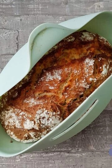 Rustikales Brot in moderner Backschale auf Holzuntergrund, handgefertigt und einladend.