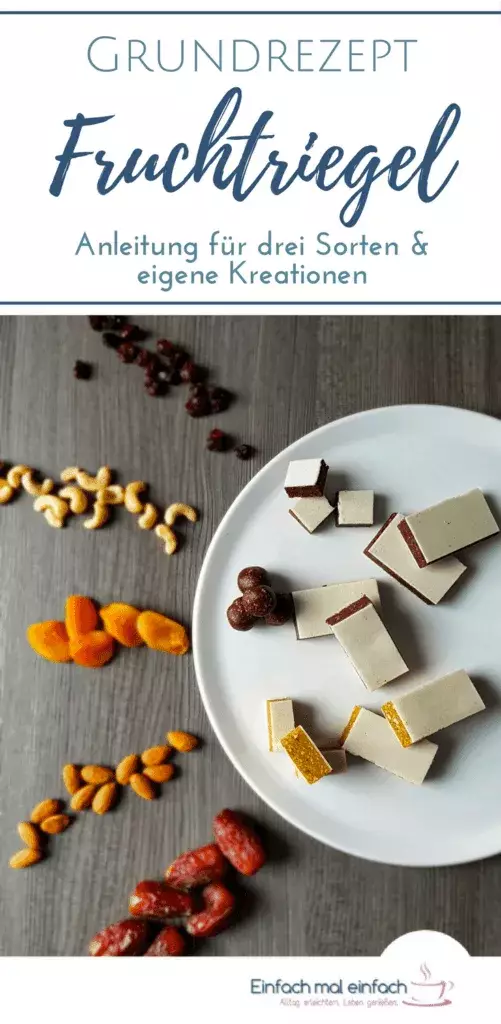 Fruchtriegel mit Oblaten in drei Varianten - tropisch-gelb, beerig-rot und schokoladig, umgeben von Nüssen, Cranberries, Schokolade, Mandeln und Kokosraspeln auf grauem Untergrund.